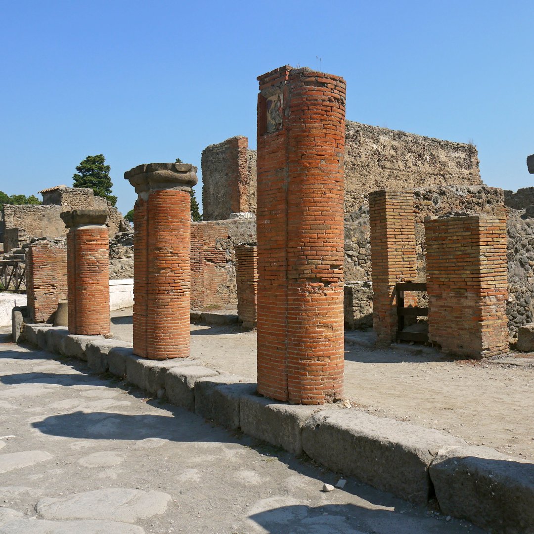 Alte colonne in laterizio lungo una strada romana lastricata negli Scavi di Pompei
