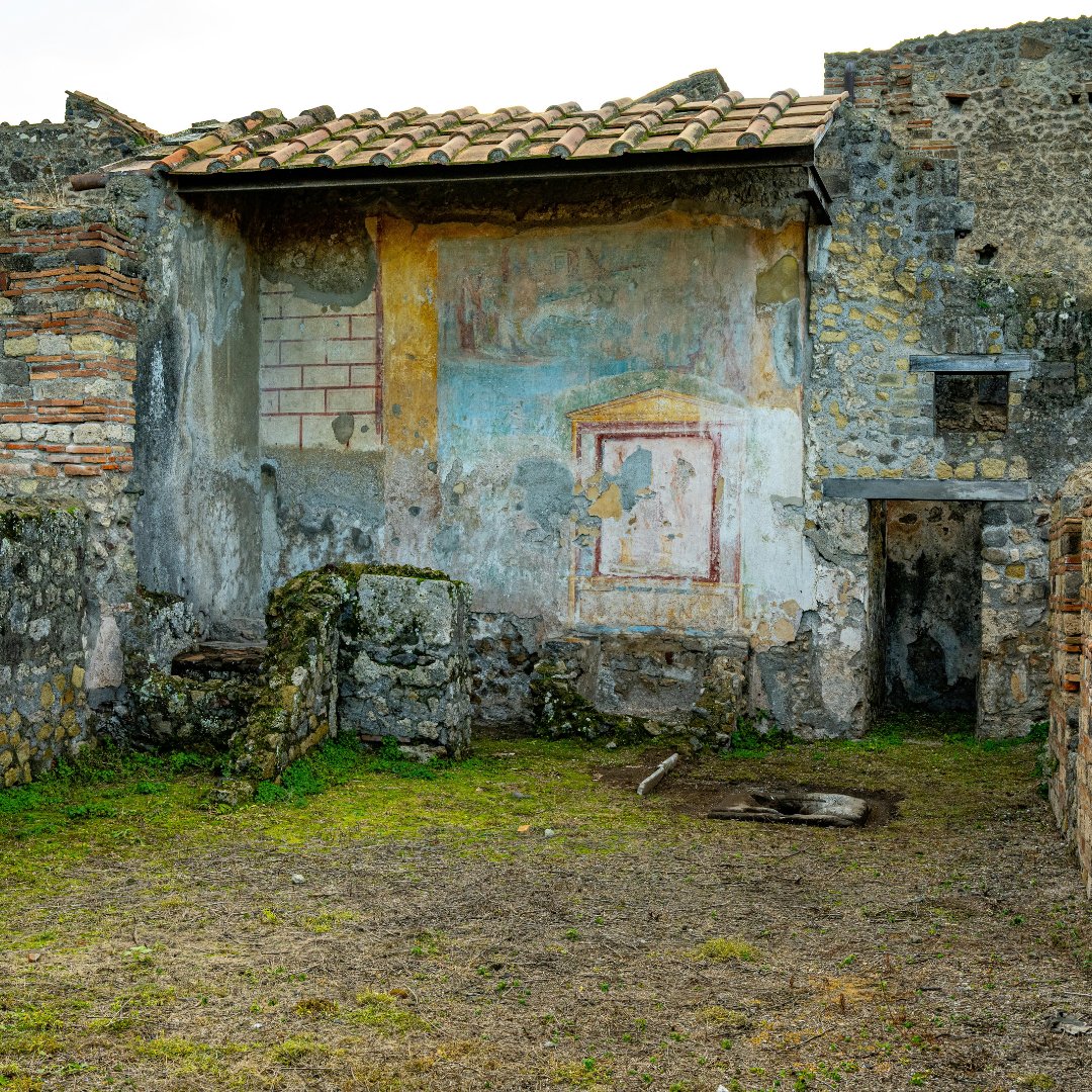 L'interno di una domus pompeiana con il sacrario dipinto originale e il tetto in tegole conservato